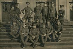 Dynion y Corfflu Hyfforddi Swyddogion ar risiau Neuadd PJ: Roedd y Corfflu ym Mangor yn un o sefydliadau cyntaf y Coleg. Yn gysylltiedig â'r Royal Garrison Artillery, y Prifathro Syr Harry R. Reichel, oedd y Capten.    