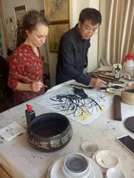 Sophie getting an introduction to Chinese ink paintings from He Rua Hua