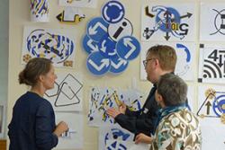 Artists Sian Hughes and Lisa Carter  look at work created at a recent event, with Steve Huxton of the Older People's Commissioner for Wales' office.