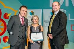 Menna Jones, Chief Executive of Antur Waunfawr, receiving the Award at the Cardiff ceremony with (left) Rhodri Thomas of Cynnal Cymru, hosts for the evening and Mat Roberts of Interserve, sponsors of the Award.