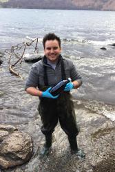 Dr Christian Dunn collecting fresh water to test for the presence of microplastics.