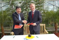 Prof Chen Jin and Prof John G Hughes exchange signed Agreements at Treborth Botanic Garden.