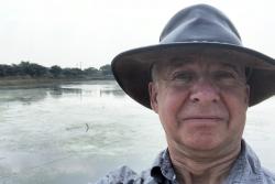 A concerned Professor Freeman at an aquaculture pond, which was formerly a rice paddy.