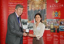 Géraldine Derroire yn derbyn ei medal gan John Giffard o Gwmni'r Brethynwyr.