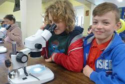 Looking down the microscope at the Hidden Worlds Exhibition at Bangor Science Festival is Cynan Roberts from Beaumaris, accompanied by his friend, Charlie Parry-Jones from Llandegfan.