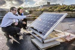 Dr Jeff Kettle and Stevie Scanlan inspecting solar panels on the roof of the School of Electronic Engineering.