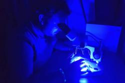 Using a fluorescence lighting system to identify and count microplastic pollutants: Image:Laura Nunnerley