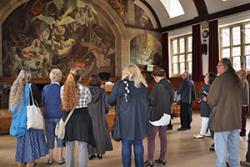 A previous tour stops in the Powis Hall to appreciate Ed Povey's Hall of Illusions mural.