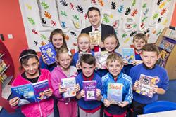 Education Minister Huw Lewis with children from Ysgol yr Hendre, during the official opening of a new community library.