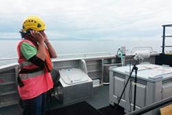 Ed Wright making a field recording on a wind turbine.